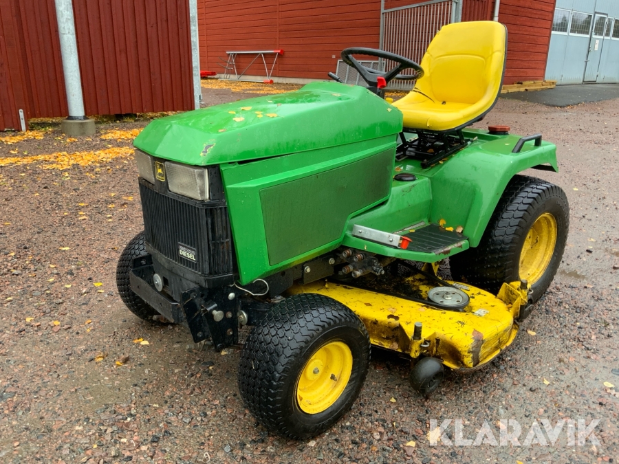 Traktor John Deere 455 med klippaggregat och sopvals