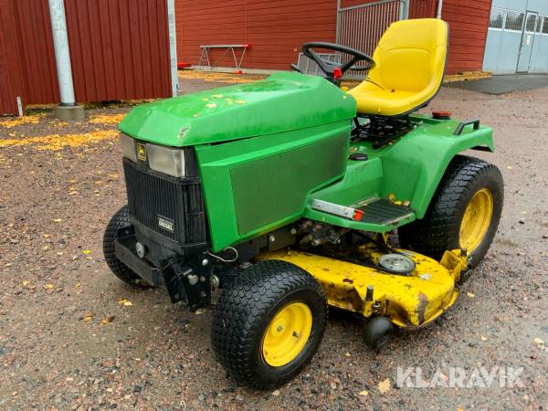 Traktor John Deere 455 med klippaggregat och sopvals