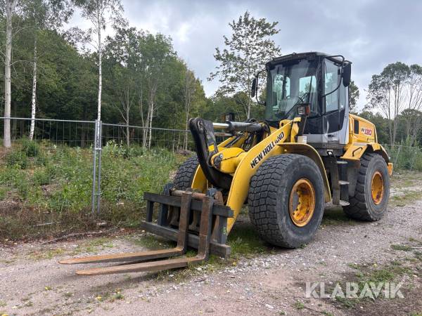 Hjullastare New Holland W130 med vikplog, skopa och gafflar