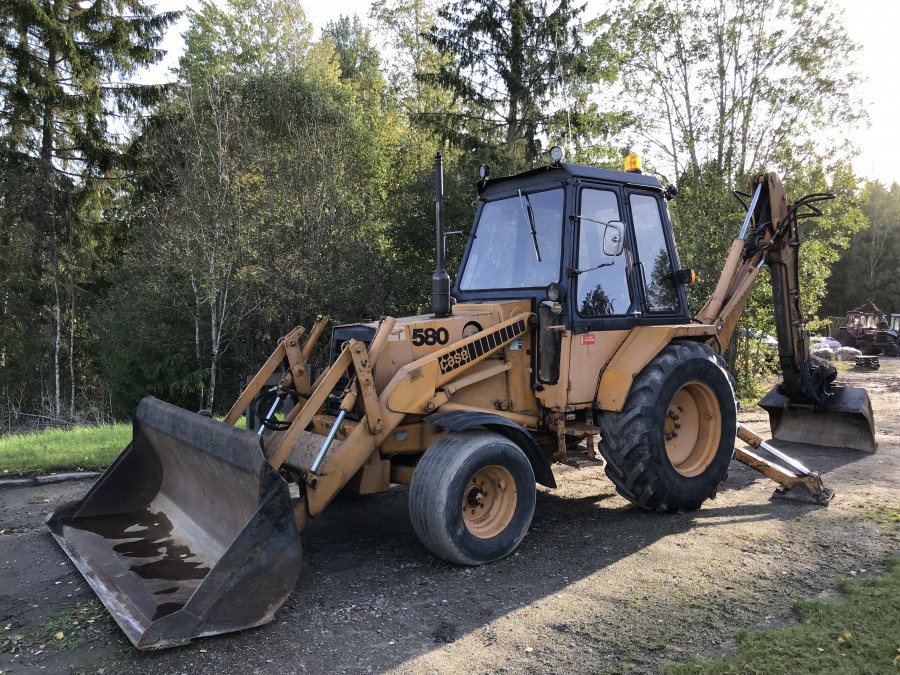 Traktorgrävare med rotator och redskap