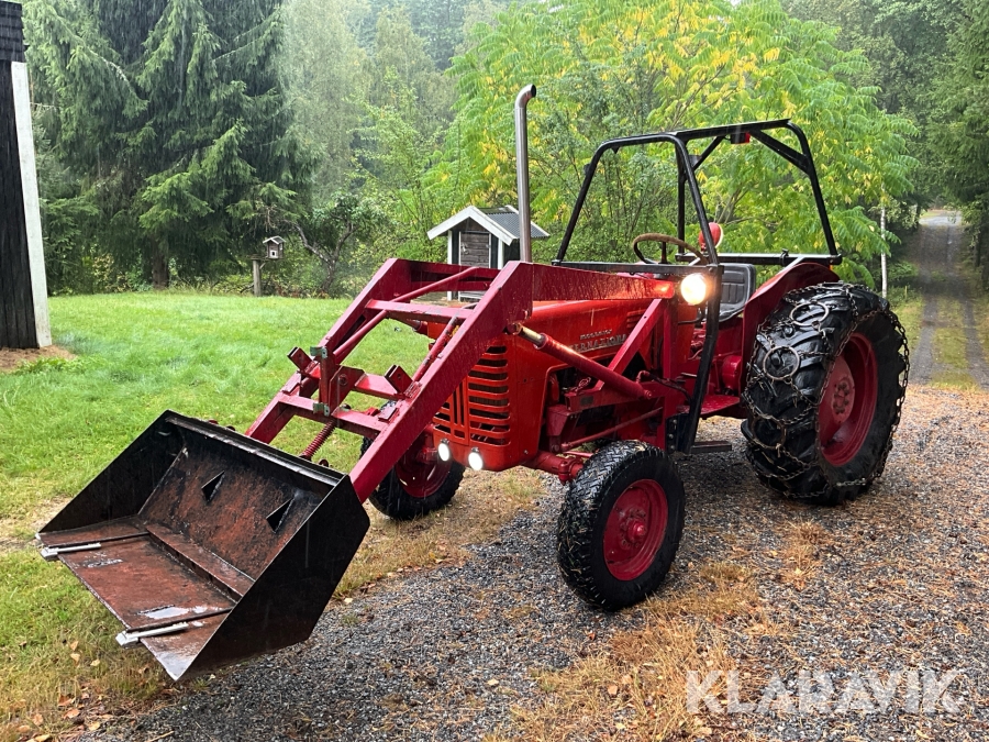 Traktor McCormick International B-250 med skopa och plogblad