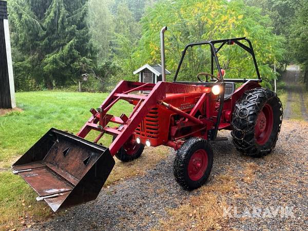 Traktor McCormick International B-250 med skopa och plogblad