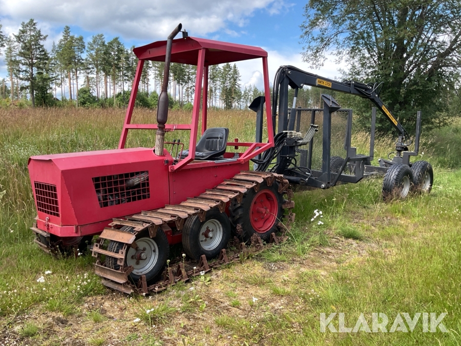 Bandtraktor med skogsvagn