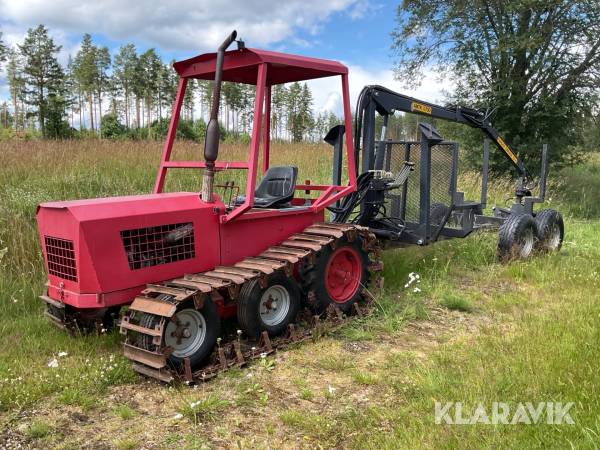 Bandtraktor med skogsvagn
