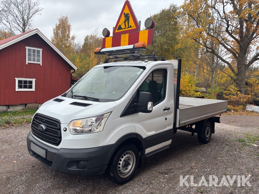 Ford Transit med flak och varningsskylt