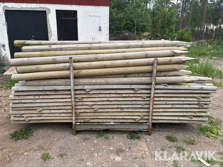 Parti med tryckimpregnerade stolpar och slanor